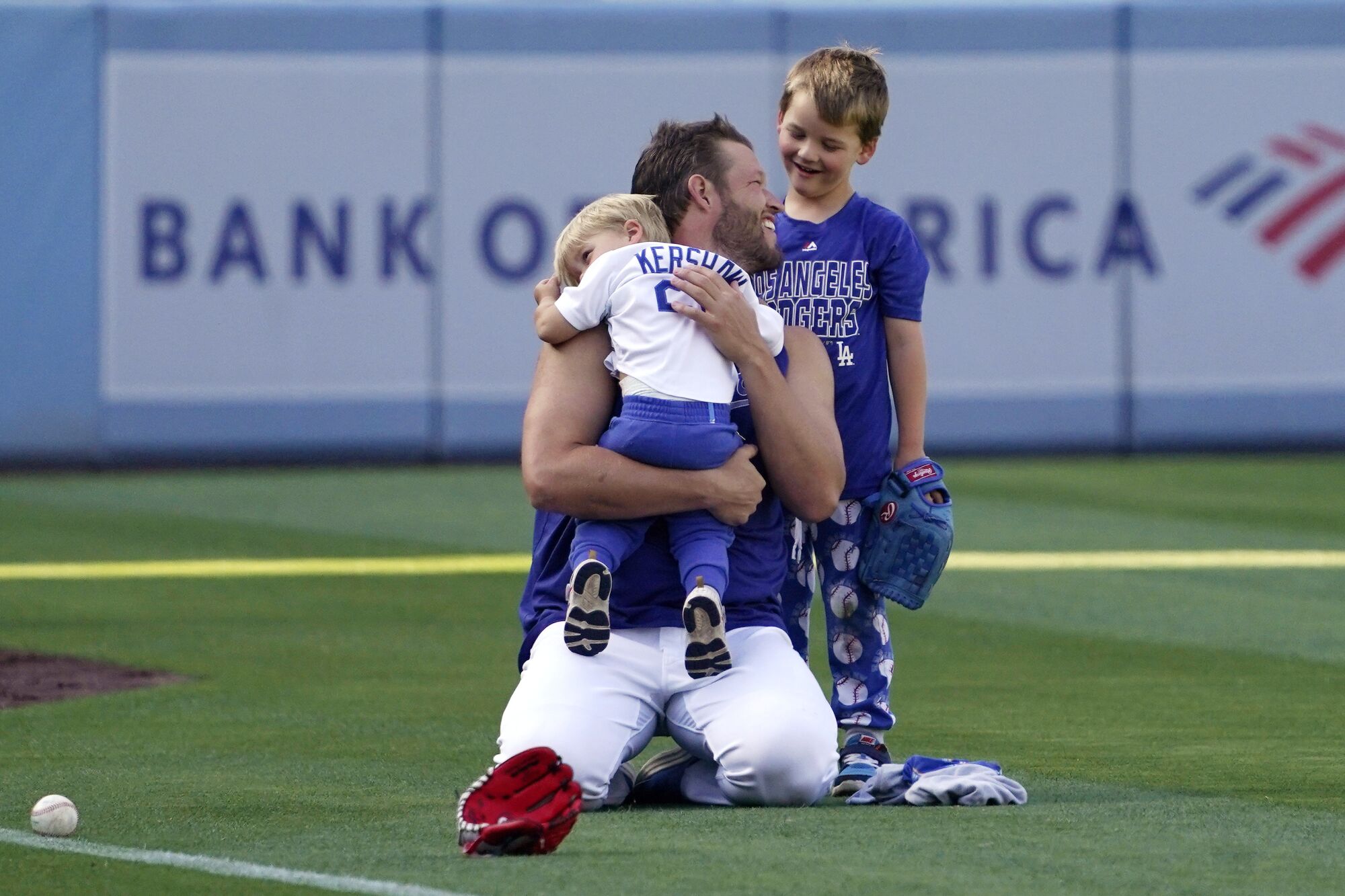 Dodgers pitcher Clayton Kershaw holds his son Cooper as his other son Charley shares a smile with Dad.
