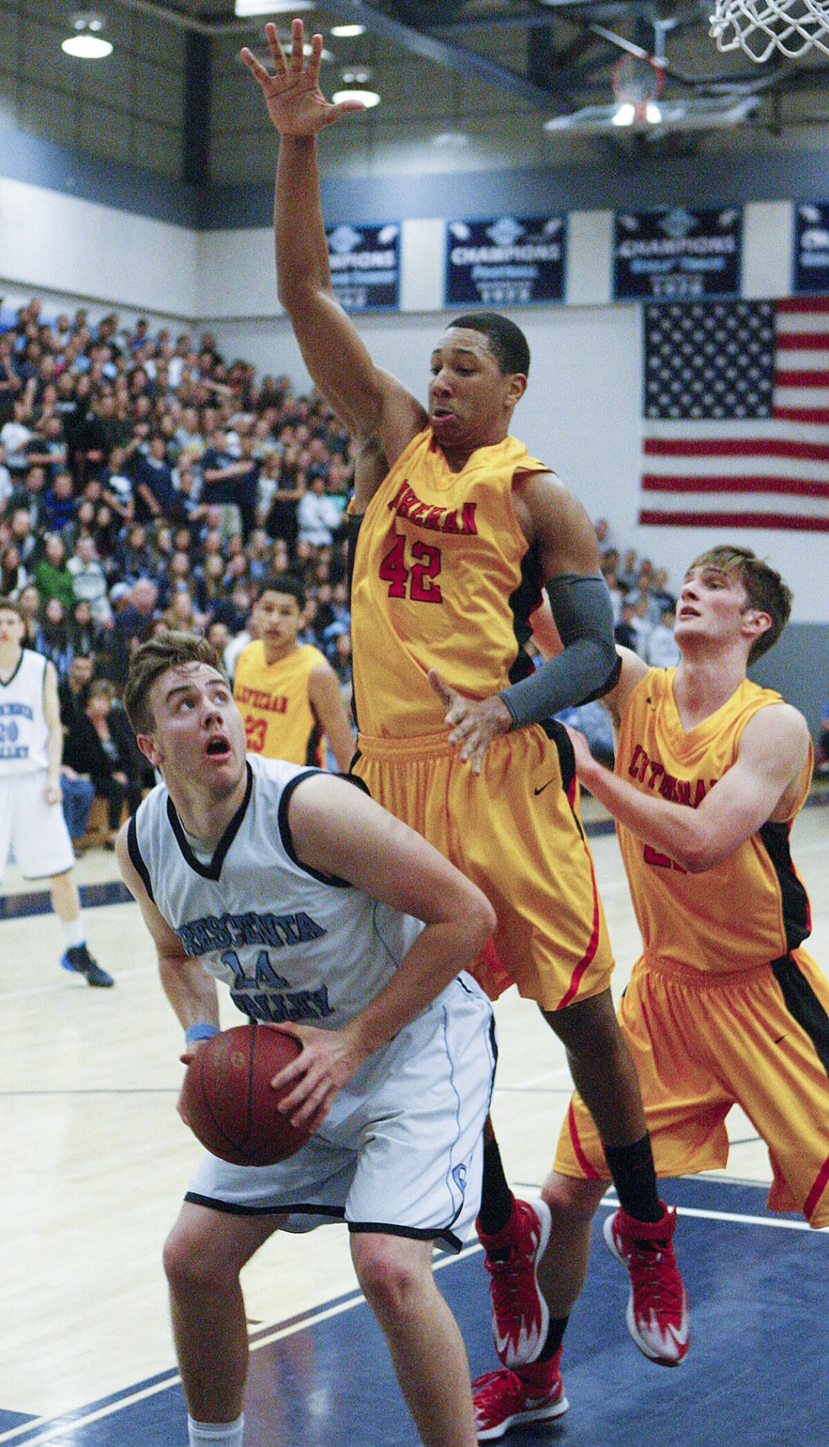 Crescenta Valley's Eric Patten waits to shoot as Orange Lutheran's Keisean Lucier-South leaves his feet to defend against the shot in a first round CIF boys basketball playoff at Crescenta Valley High School on Thursday, February 20, 2014.