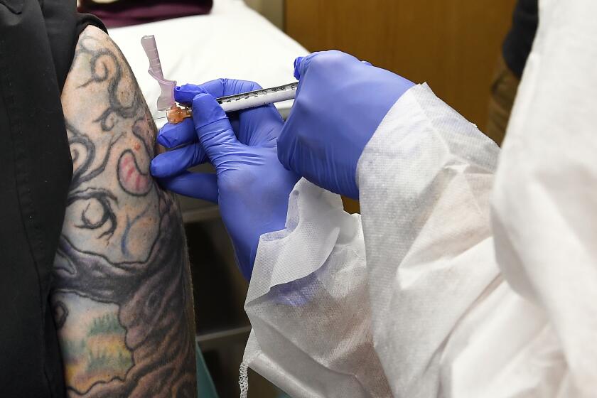 A nurse gives volunteer Melissa Harting, of Harpersville, N.Y., an injection of the experimental COVID-19 vaccine developed by Moderna and the National Institutes of Health.