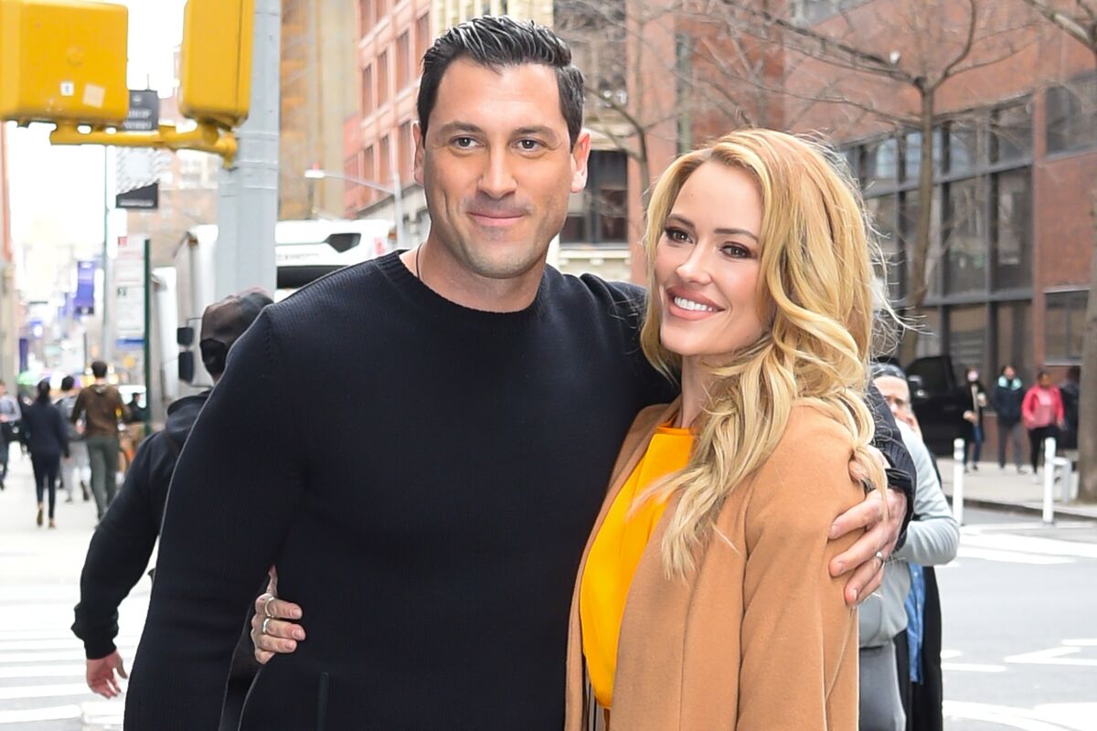 A man and a woman stand with arms around each other on a New York street