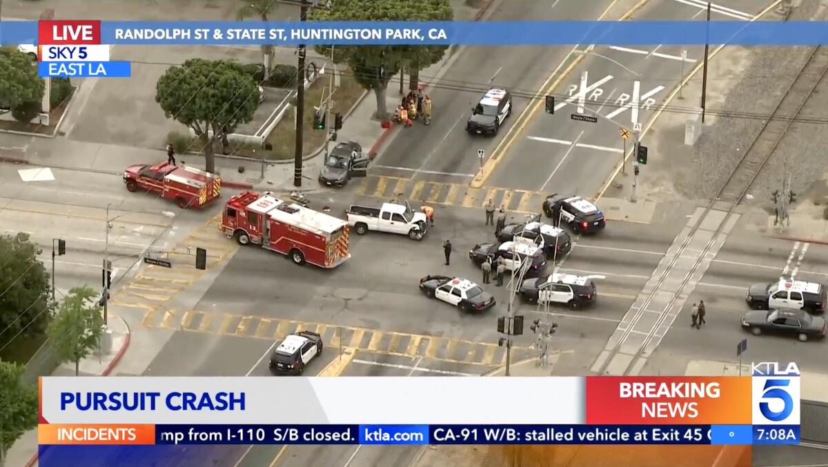 Aerial view of police cruisers, an ambulance and a fire truck in an intersection with two crashed vehicles