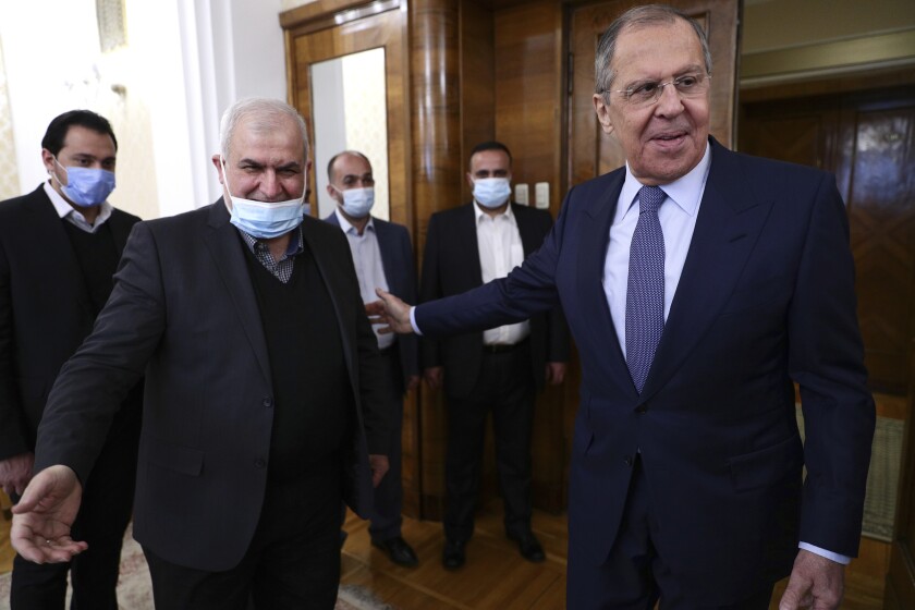 In this photo released by Russian Foreign Ministry Press Service, Russian Foreign Minister Sergey Lavrov, right, welcomes the head of Hezbollah parliamentary bloc Mohamad Raad for talks during their meeting in Moscow, Russia, Monday, March 15, 2021. (Russian Foreign Ministry Press Service via AP)