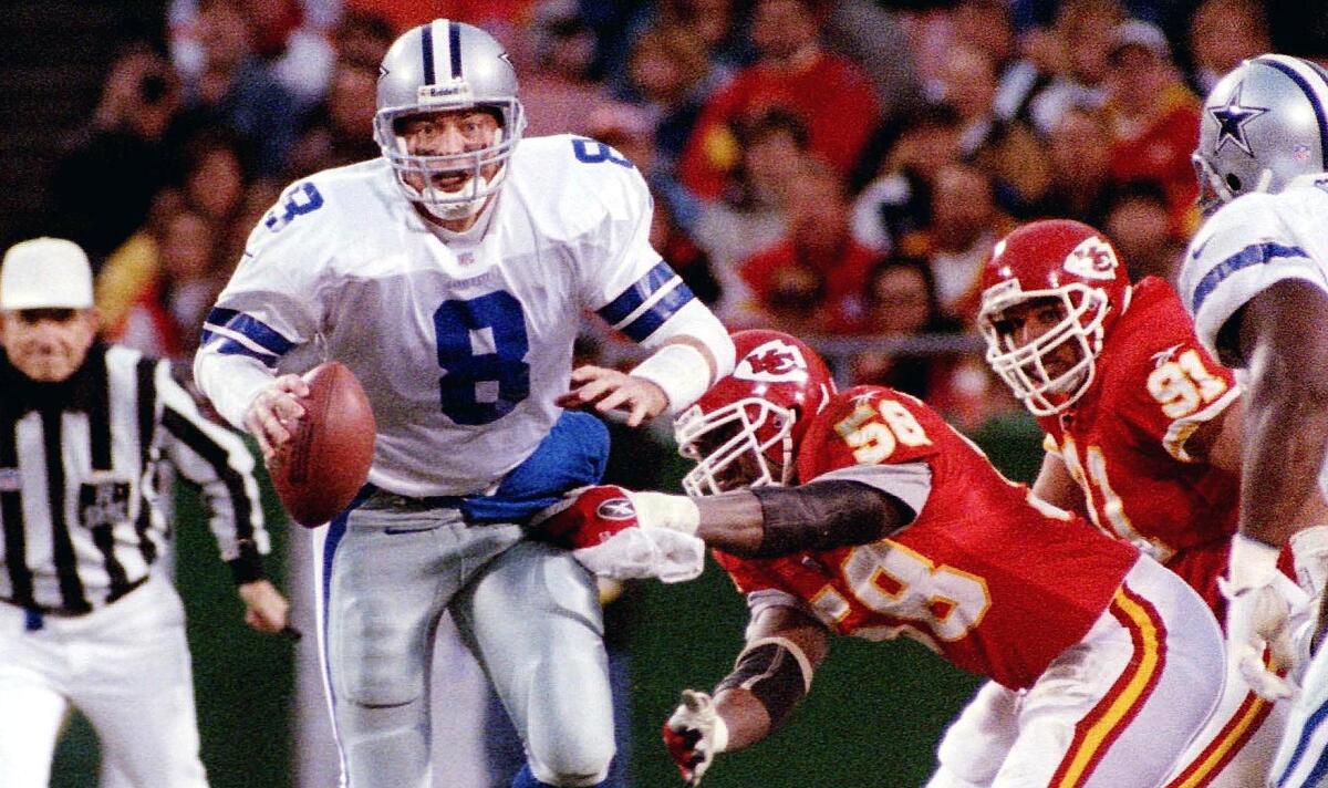 Cowboys quarterback Troy Aikman is sacked by Chiefs linebacker Derrick Thomas during a game in 1998.