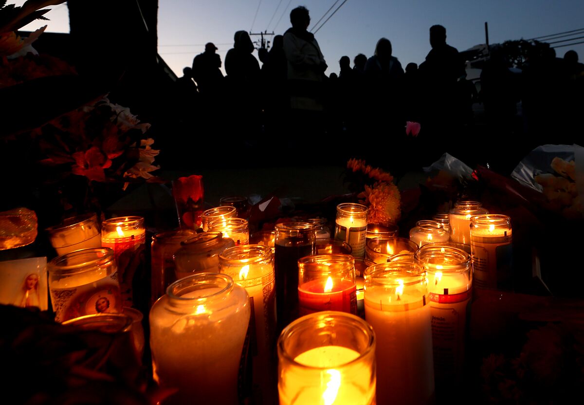 Candles burn with people in the background