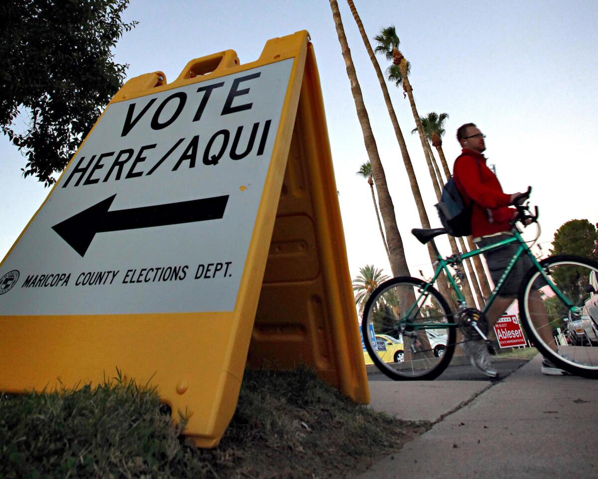 A sign directs voters to a polling station in Tempe, Ariz.