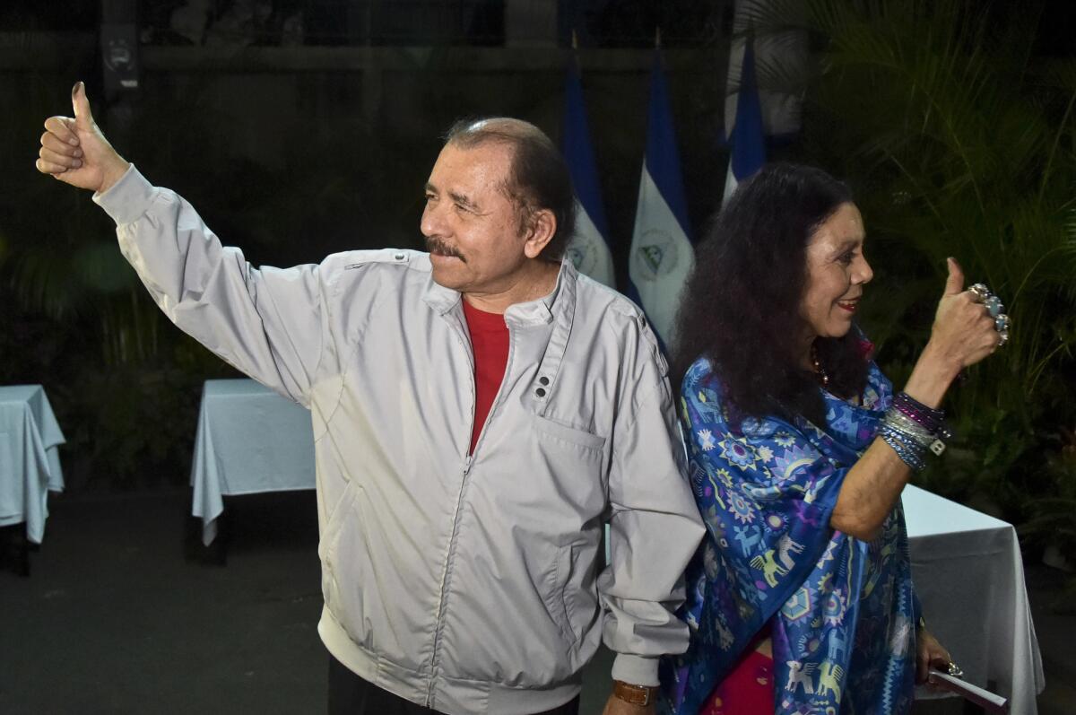 Nicaragua's President Daniel Ortega and his wife, vice presidential candidate Rosario Murillo, show their marked thumbs after voting at a polling station near a their home in Managua, Nicaragua, on Nov. 6, 2016.