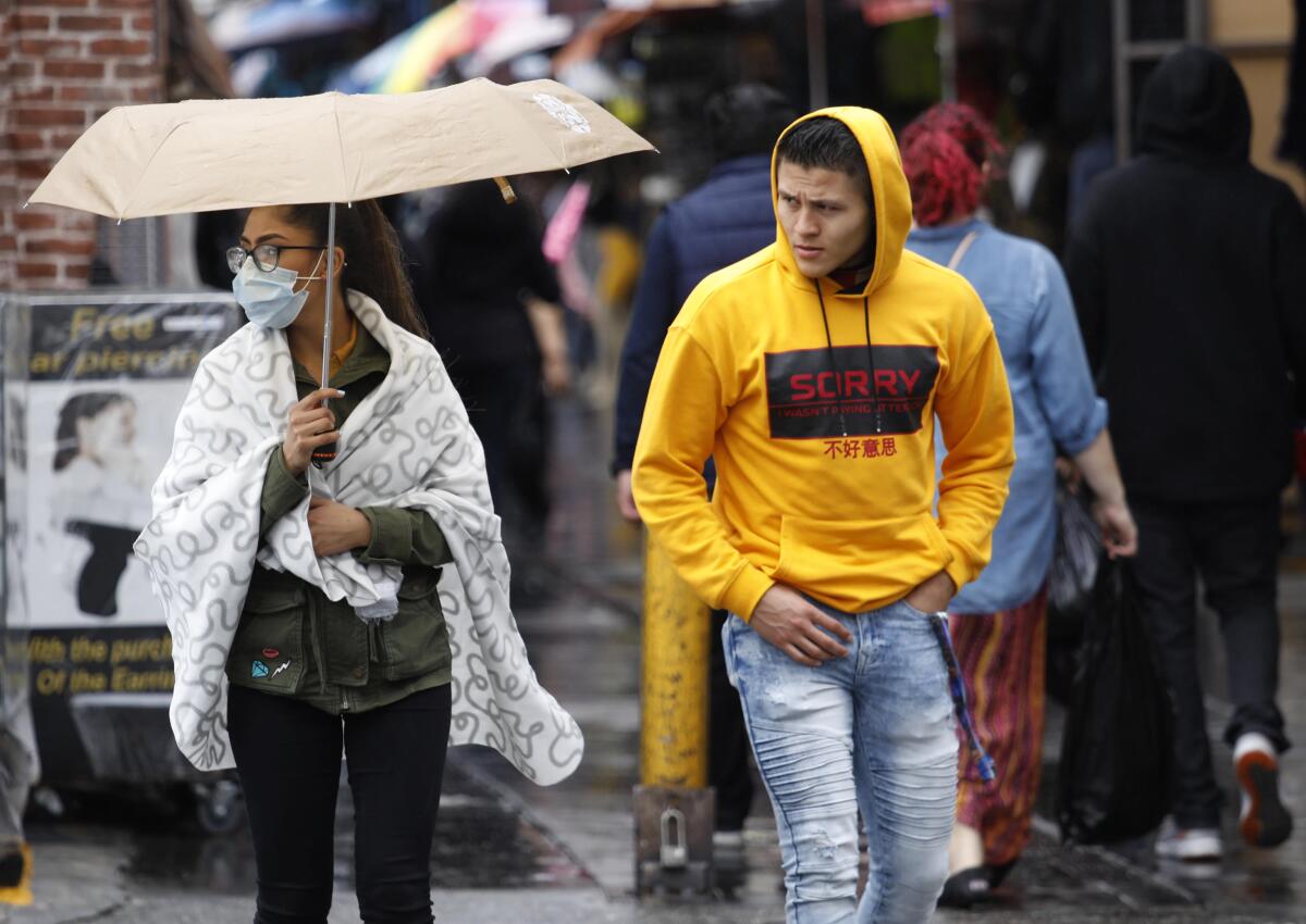 Greyly Sanchez, 18, wears a surgical mask while shopping with Miguel Henriquez, 21, on Santee Alley.