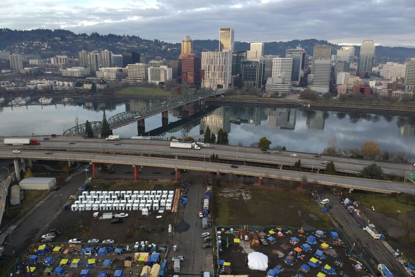 FILE - In this aerial photo, tents housing people experiencing homelessness are set up on a vacant parking lot in Portland, Ore., Dec. 8, 2020. Portland's city council voted Wednesday, June 7, 2023, to pass an ordinance prohibiting camping during daytime hours in most public places as it, along with other U.S. cities, struggles to address a longtime homelessness crisis. (AP Photo/Craig Mitchelldyer, File)