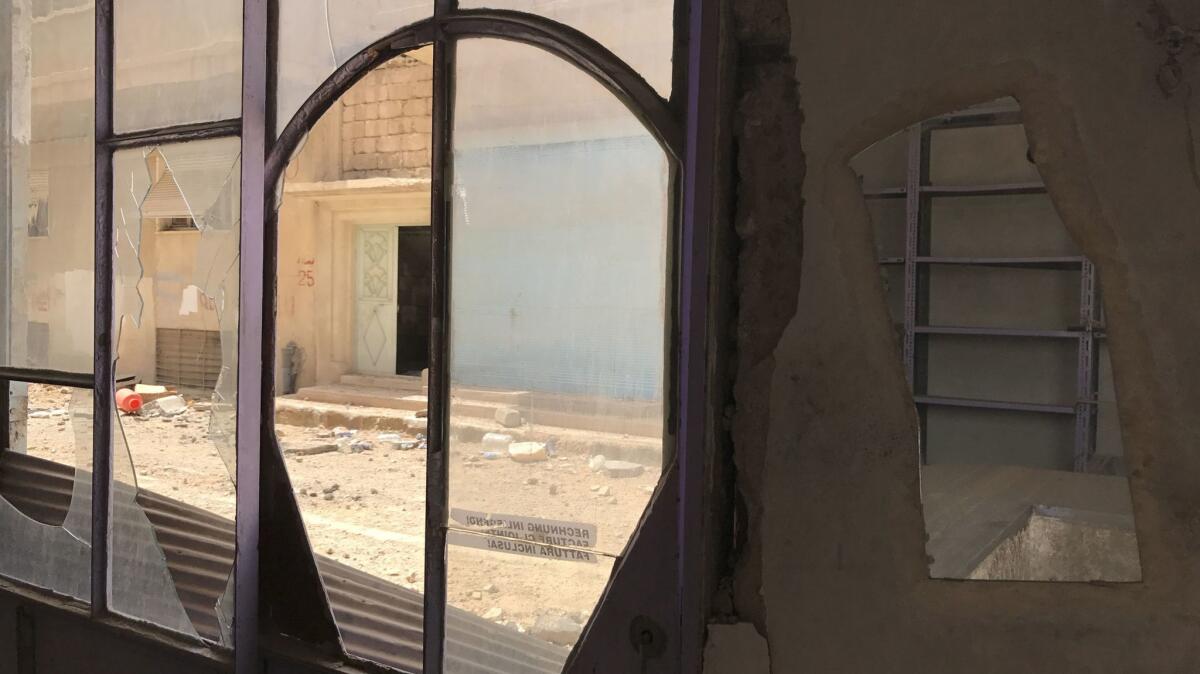 A battered storefront in Palmyra, Syria. During the militant occupation, shop owners had to abide by a "pledge statement" committing them to observe the strict requirements of Islamic State's morality police.