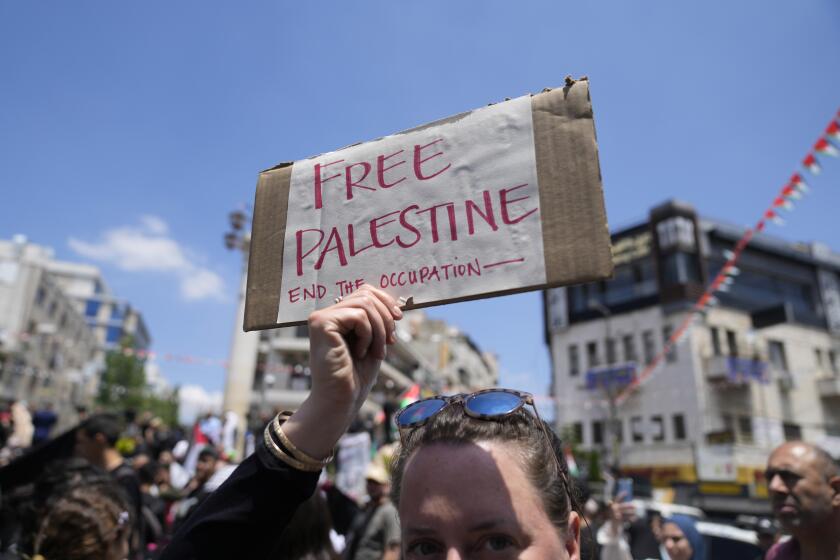 An activist holds a poster during a mass ceremony to commemorate the Nakba Day, Arabic for catastrophe, in the West Bank city of Ramallah, Wednesday, May 15, 2024. Palestinians are marking 76 years of dispossession on Wednesday, commemorating their mass expulsion from what is today Israel, as a potentially even larger catastrophe unfolds in Gaza, where more than half a million of people have been displaced in recent days by fighting. (AP Photo/Nasser Nasser)