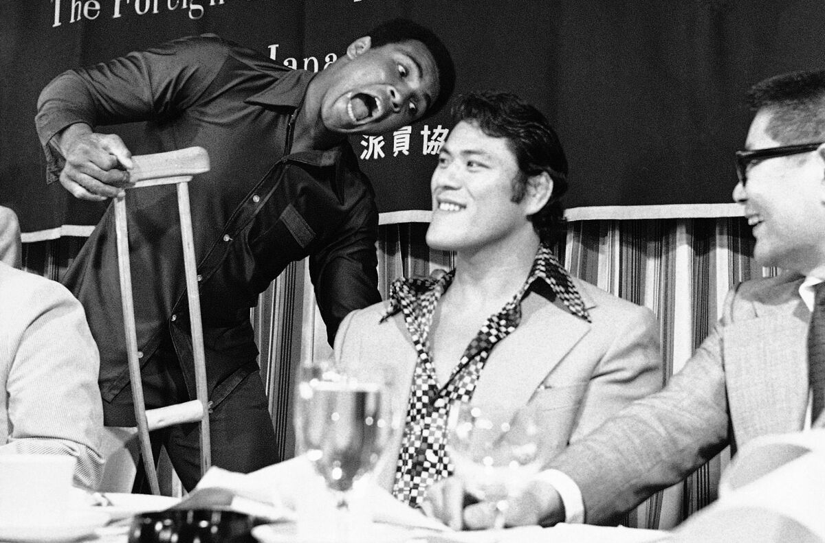 Muhammad Ali re-gifts a crutch to Antonio Inoki. (Associated Press)