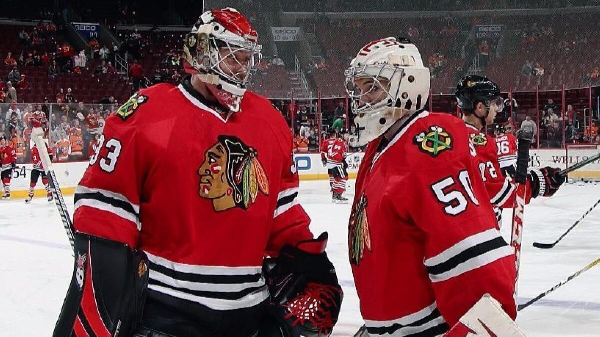 Blackhawks goalie Scott Darling (33) talks with Eric Semborski (50) during warmups before a game against the Flyers on Dec. 3.