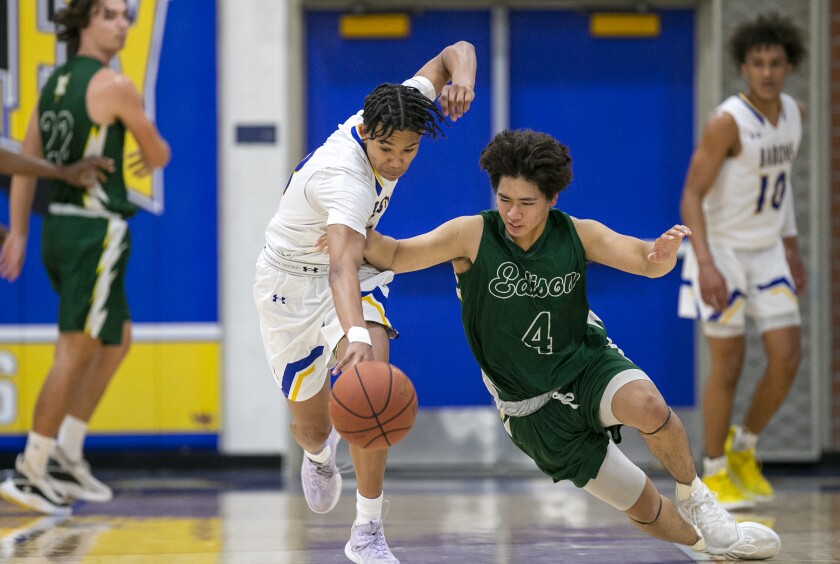 Fountain Valley's E.J. Bryson scrambles for a loose ball against Edison's Jackie Kwok on Wednesday.
