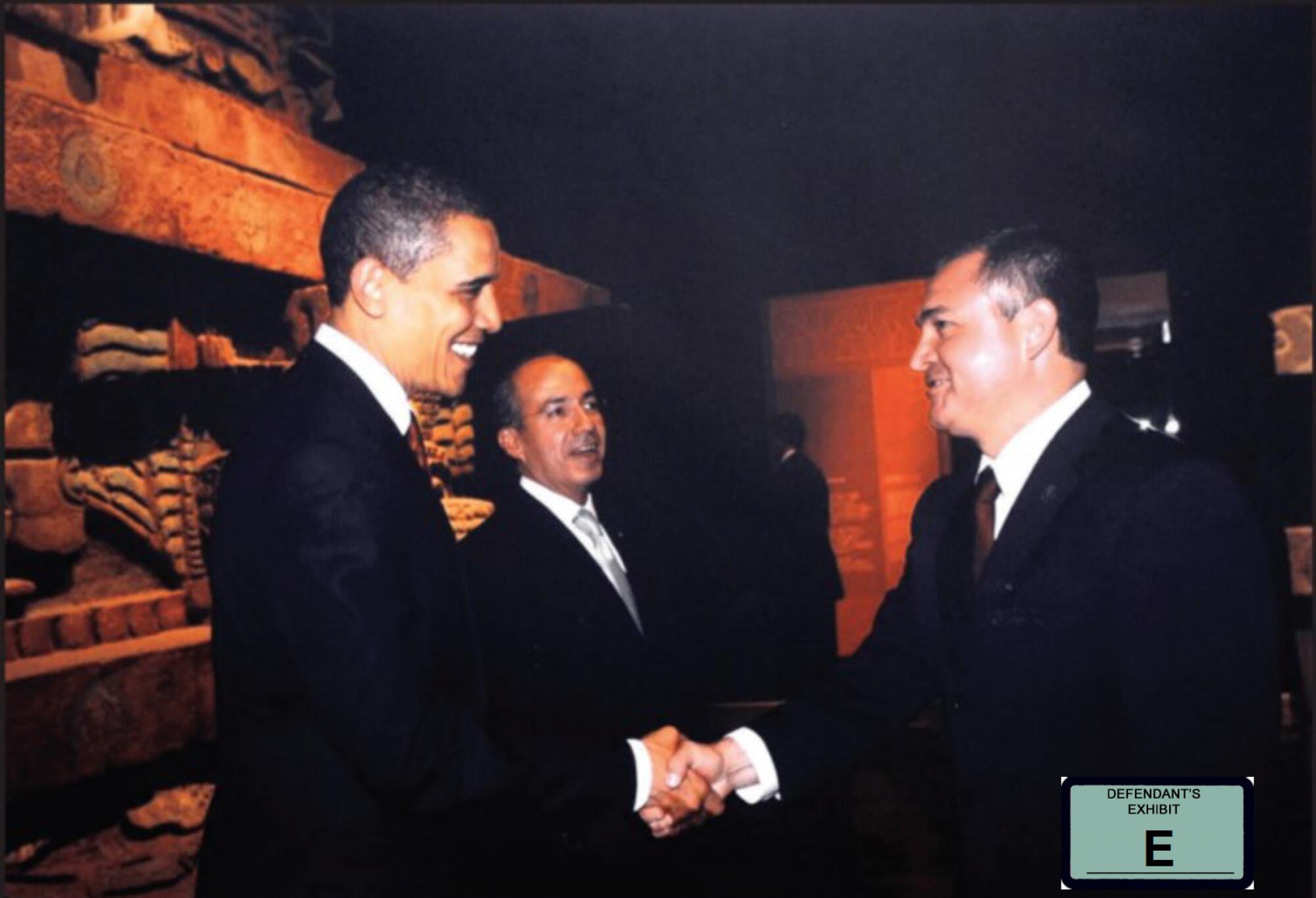 Genaro García Luna, right, shaking hands with former President Obama