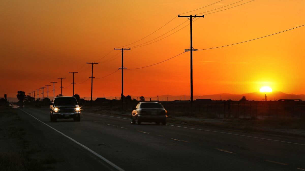 Motorists travel at sunset along Cecil Avenue in Delano, near the site where Santos Hilario Garcia and Marcelina Garcia Prefecto died in a crash while fleeing ICE.
