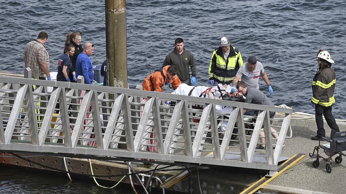 Emergency response crews transport an injured passenger to an ambulance at the George Inlet Lodge docks on May 13 in Ketchikan, Alaska.