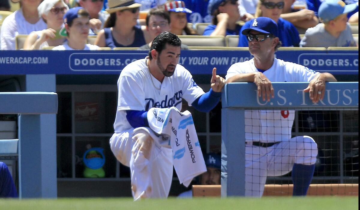 Dodgers Manager Don Mattingly, right, chats with first baseman Adrian Gonzalez during a game late in the regular season.