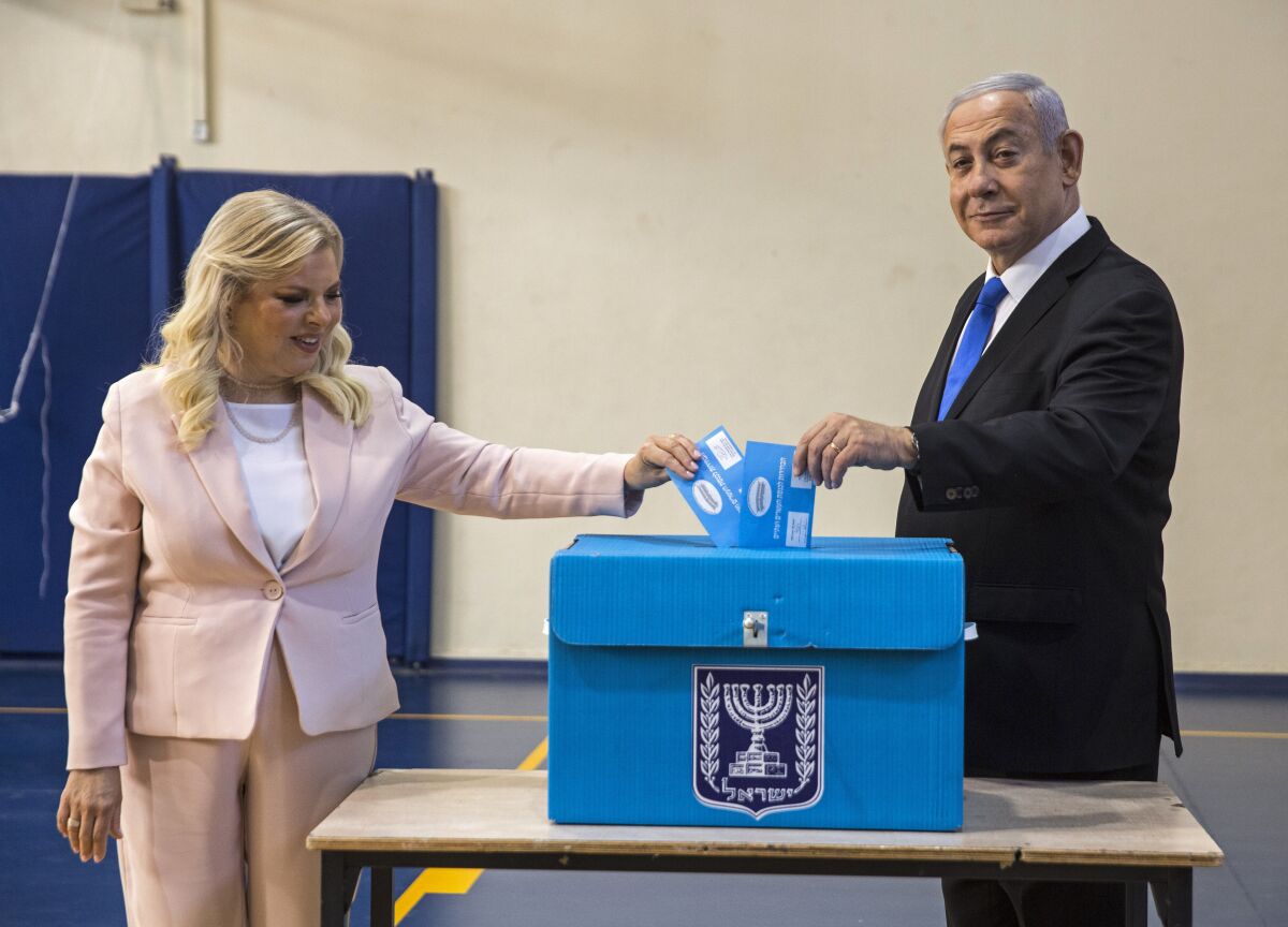 FILE - Israeli Prime Minister Benjamin Netanyahu and his wife Sarah casts their votes at a voting station in Jerusalem, Sept. 17, 2019. On Sunday Dec. 12, 2021, an Israeli parliamentary committee voted to stop providing personal security details to former prime minister Benjamin Netanyahu’s wife and adult sons. The decision comes six months after the longtime leader was ousted from power. As opposition leader, he will continue to have a security detail and private driver. (Heidi Levine, Sipa, Pool via AP, File).