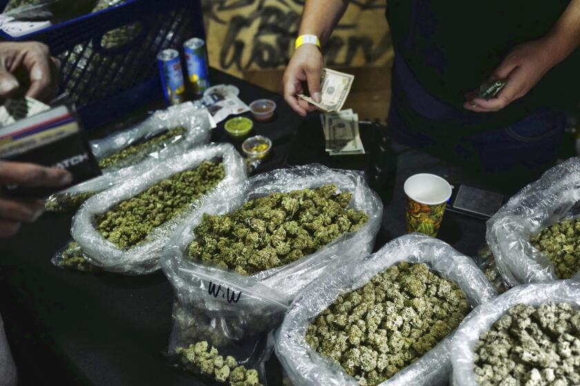 FILE - In this April 15, 2019, file photo, a vendor makes change for a marijuana customer.