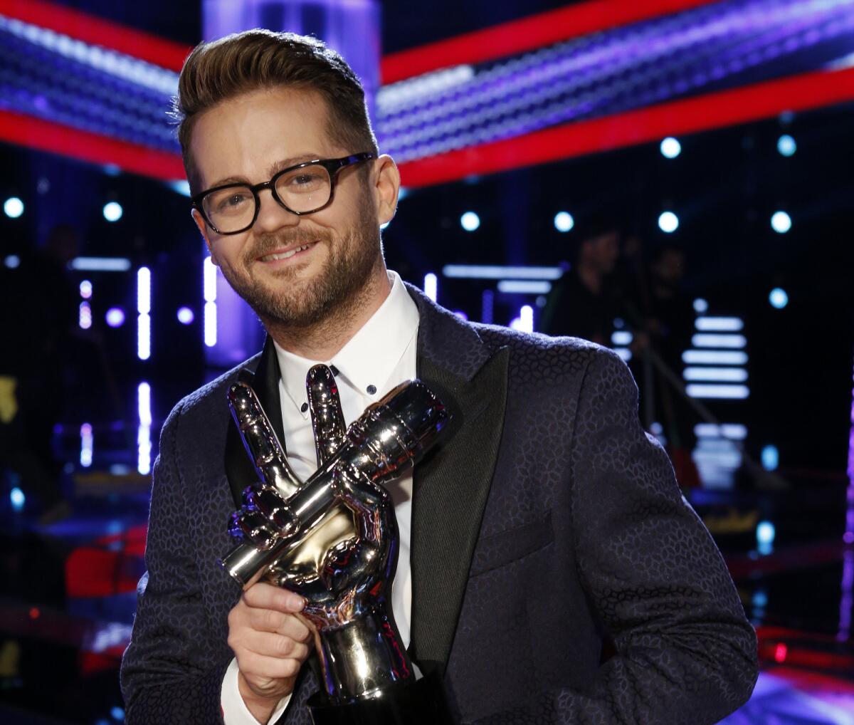 Josh Kaufman holds the trophy he won after placing first on the singing competition series "The Voice" on NBC.