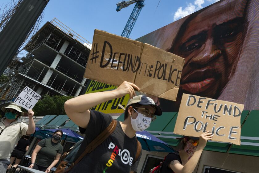 Protesters pass a billboard image of George Floyd as they march past Centennial Olympic Park during a protest over the death of Floyd, Saturday, June 13, 2020 in Atlanta. (John Amis/Atlanta Journal-Constitution via AP)