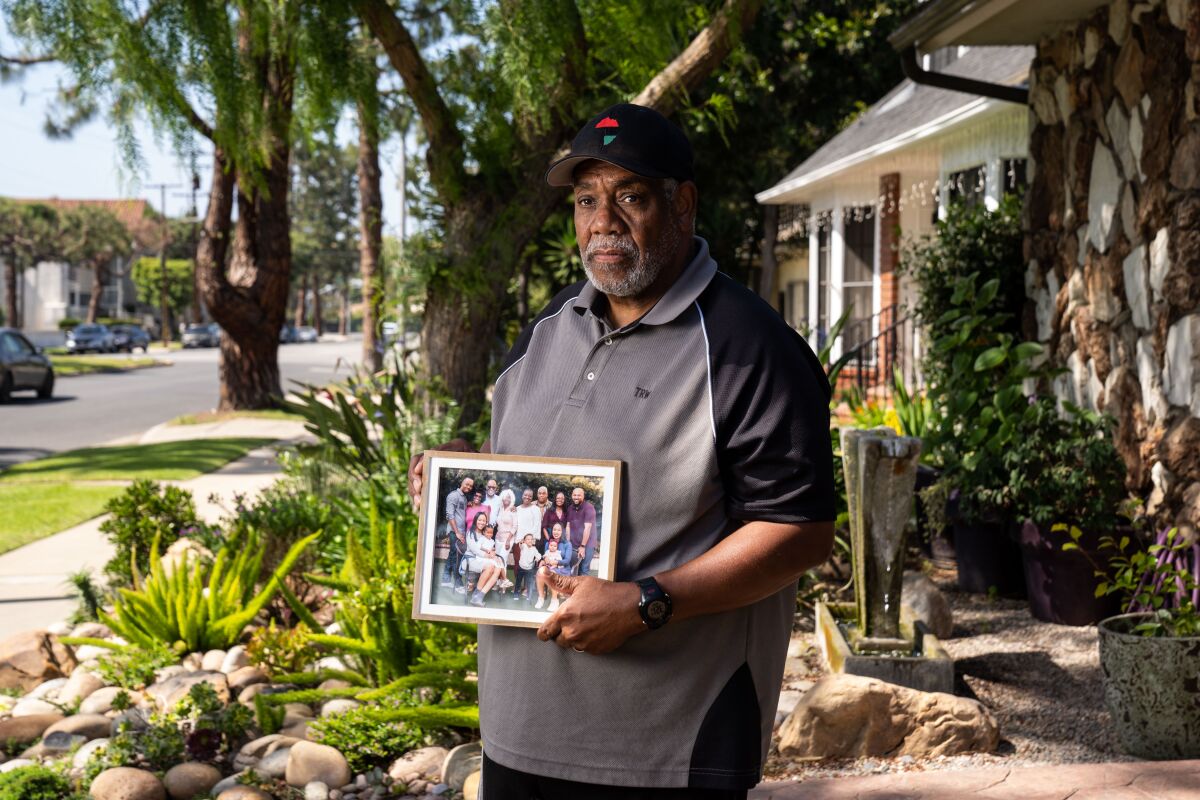 Tony Wafford, with a photo of extended family members, outside his home in Inglewood.