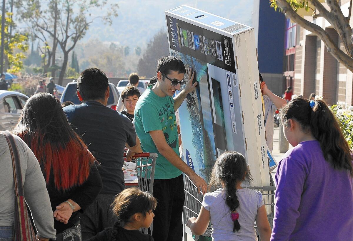 A customer leaves the Best Buy store in Los Feliz with his new big-screen television on Black Friday in 2014.