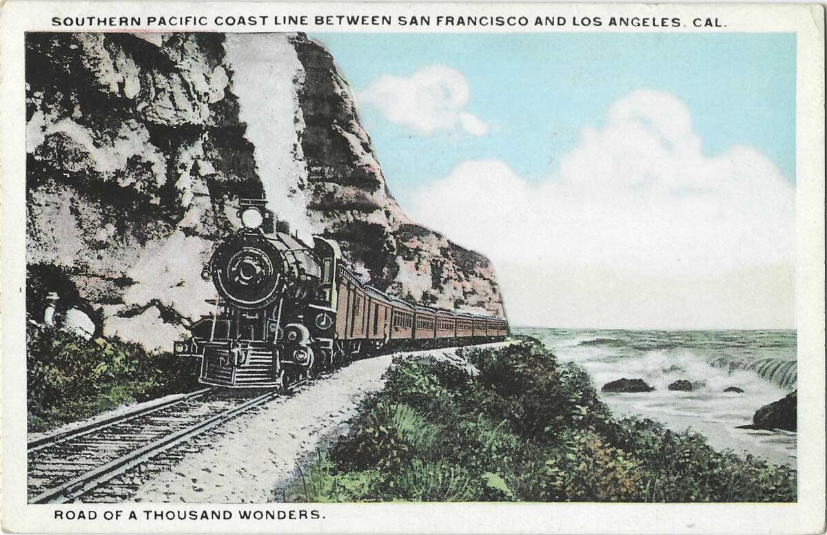 A train travels the California coastline, with cliffs on its left and the surf on its right.
