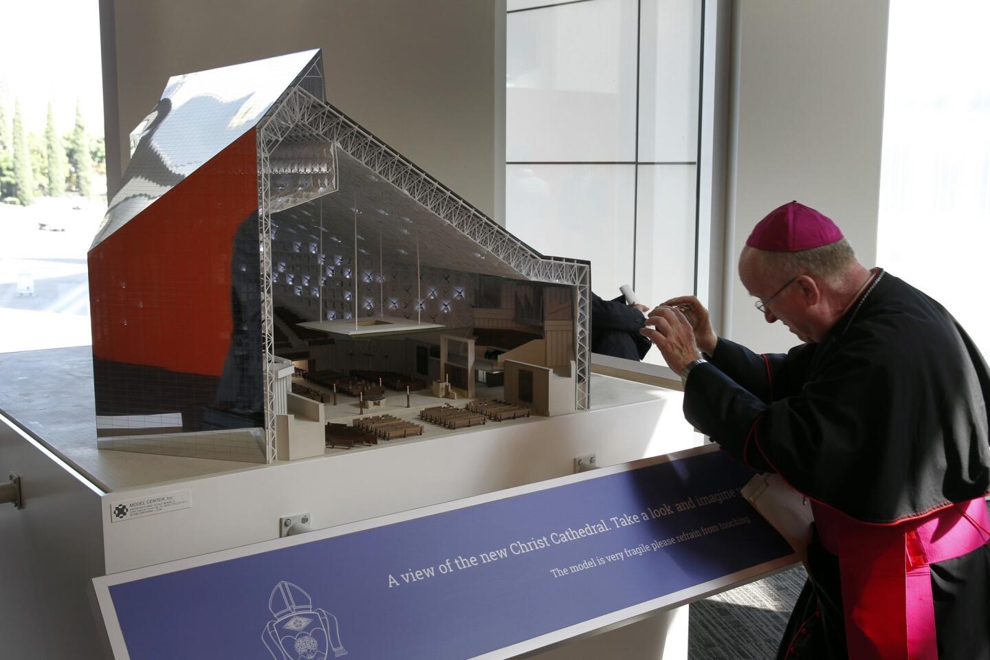 Bishop Rev. Kevin Vann takes a photo of a conceptual design model of the future Christ Cathedral, set to open in 2017.