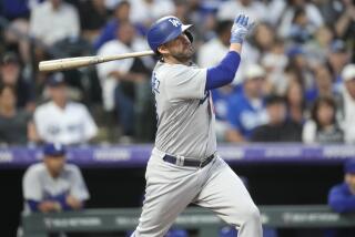 Los Angeles Dodgers' J.D. Martinez follows the flight of his two-run home run off Colorado Rockies.