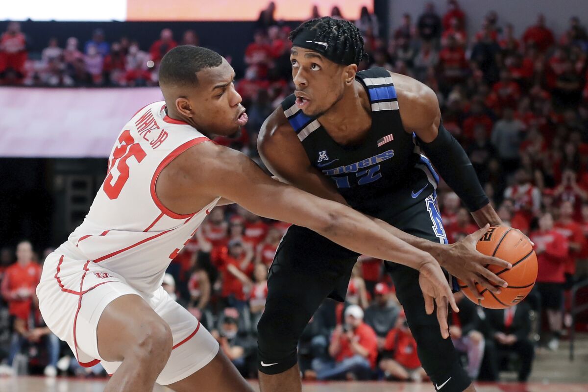 Houston forward Fabian White Jr. (35) reaches in as Memphis forward DeAndre Williams, right, looks for a shot during the first half of an NCAA college basketball game Saturday, Feb. 12, 2022, in Houston. (AP Photo/Michael Wyke)