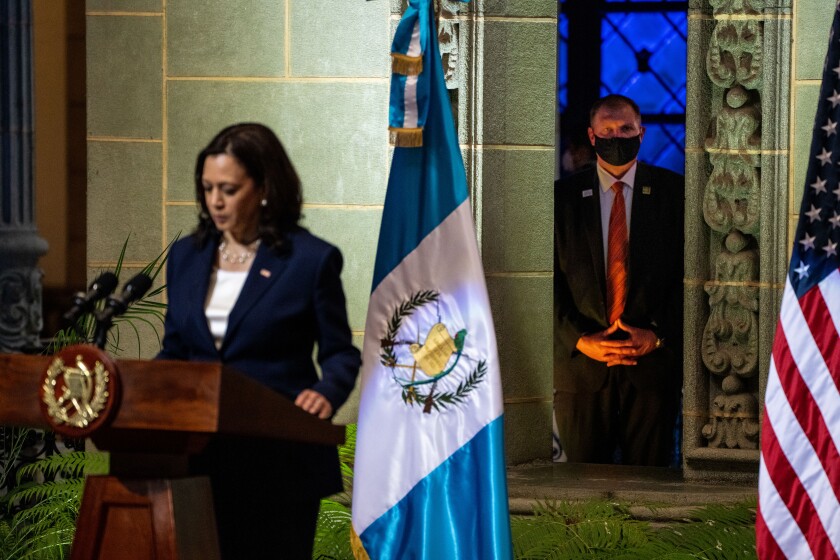 An agent stands by as Vice President Kamala Harris takes part in a news conference in Guatemala City.