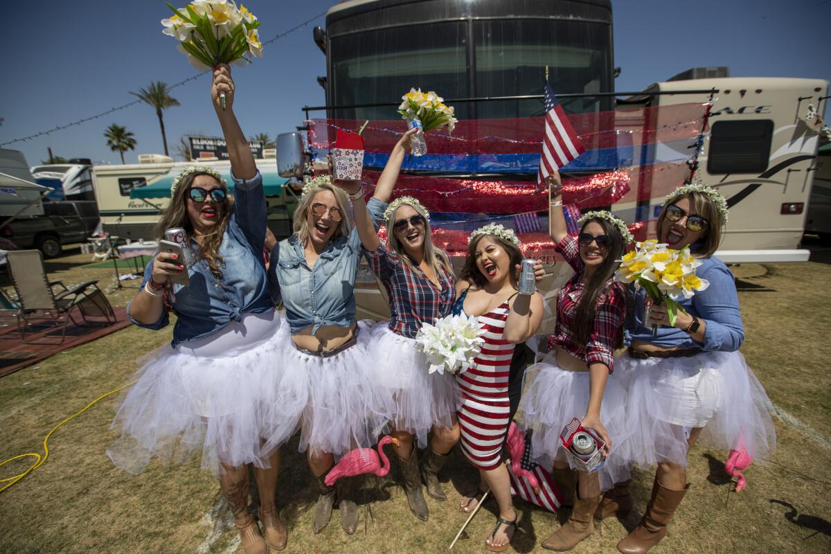 Bridesmaids surround Karina Workman, center, in stripes, of West Covina, who celebrates her five-year wedding renewal to her husband, Greg, while listening to country music at Stagecoach.