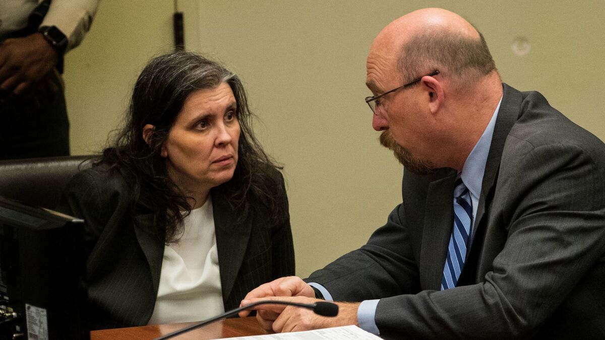 Louise Turpin consults with attorney Jeff Moore before she and her husband David Turpin plead not guilty to multiple felony charges during an arraignment at the Riverside Hall of Justice.