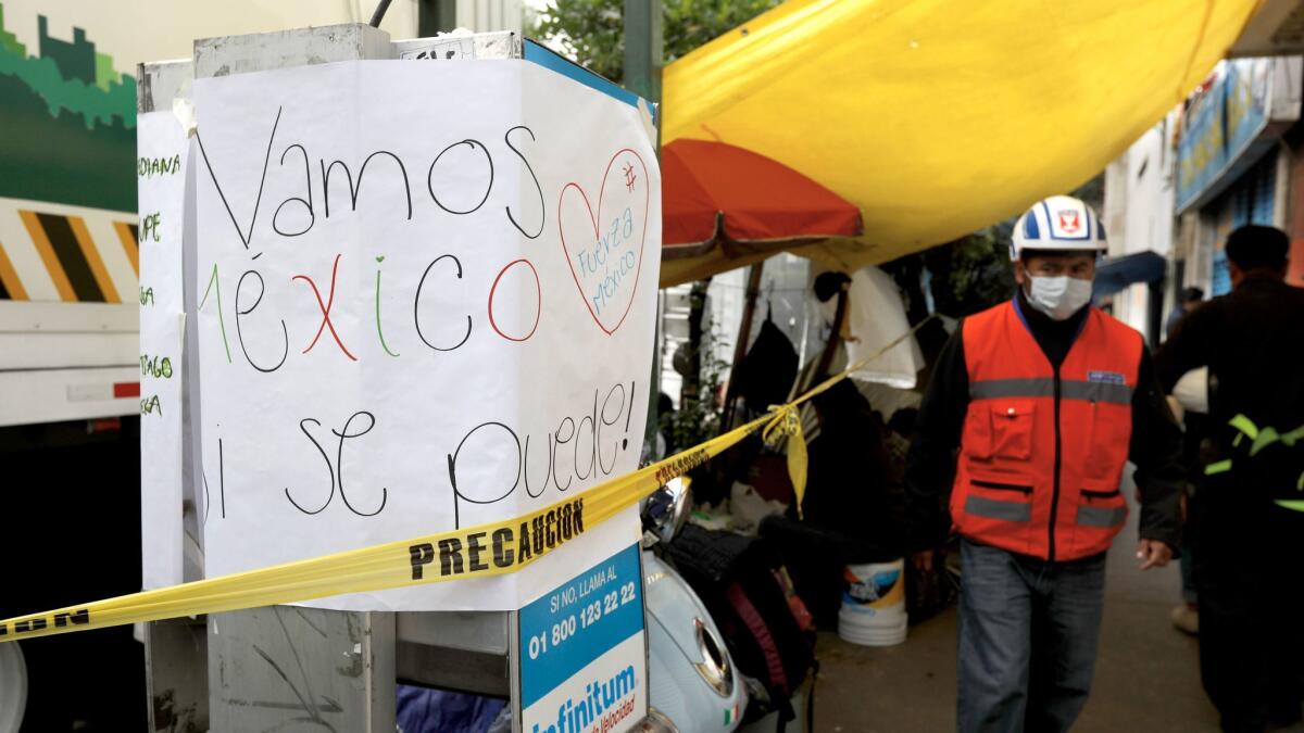 A sign reads: "Let's go Mexico. Yes we can," on a payphone near where families camp waiting for news of loved ones as the search for victims continues in Mexico City's Condesa district.