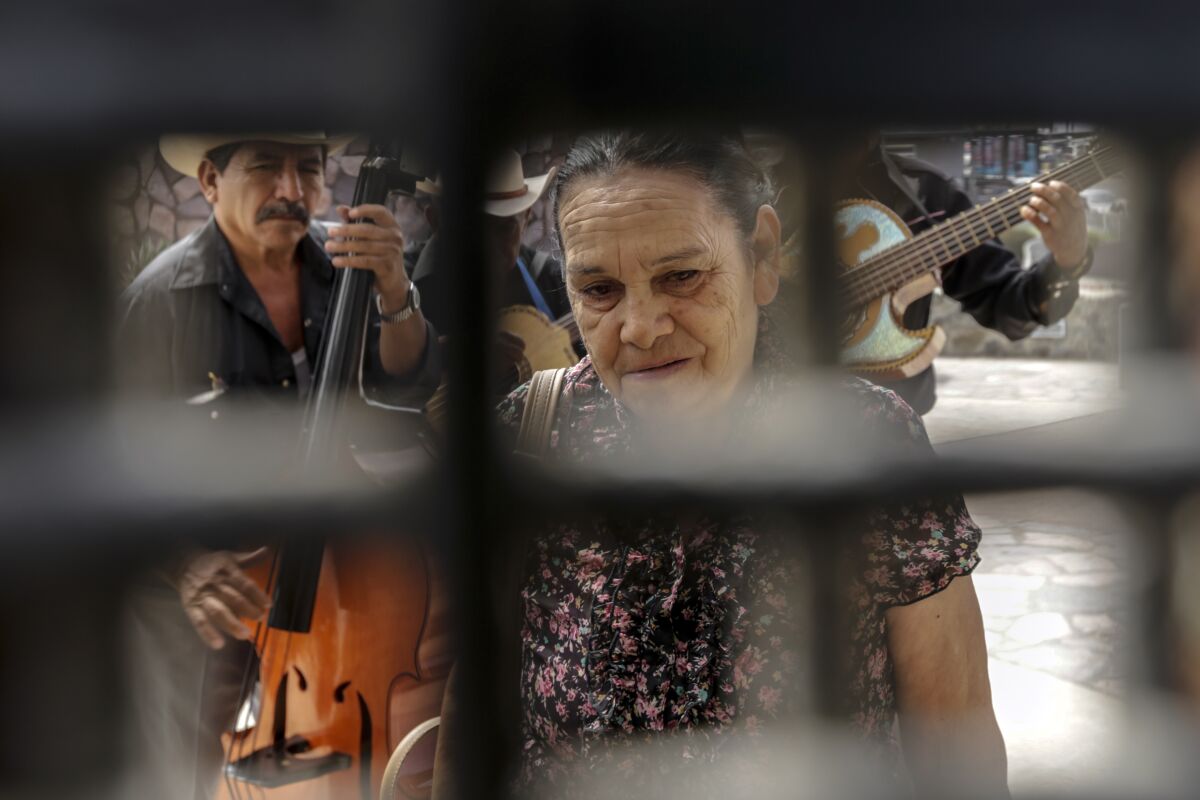 Standing on the Mexican side of the border in Friendship Park in 2016, Eva Arguello, 71, looks through the fence for her son.