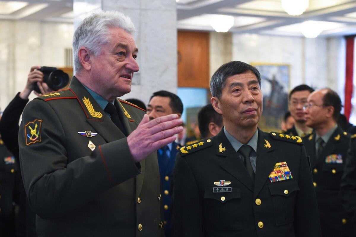 In this handout photo released by Russian Defense Ministry Press Service, Chief of the Military Academy of the General Staff of the Armed Forces of the Russian Federation Col. Gen. Vladimir Zarudnitsky, left, escorts China's Defense Minister Gen. Li Shangfu during a visit to Military Academy of the General Staff of the Armed Forces of the Russian Federation in Moscow, Russia, Monday, April 17, 2023. (Russian Defense Ministry Press Service via AP)