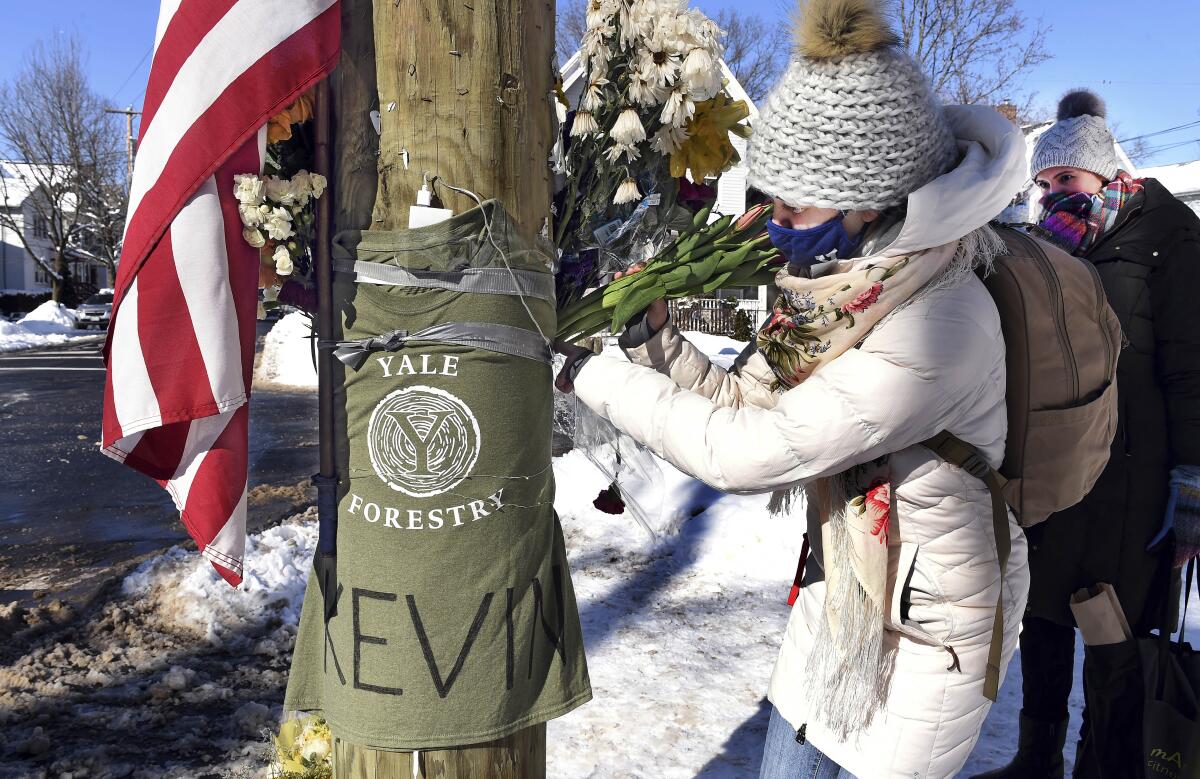 FILE — In this Feb. 8, 2021 file photo, Yale postdoctoral students Maria Kochugaeva, left, and Elvira Mulyukova leave flowers at a memorial for Yale School of the Environment grad student Kevin Jiang, near where he was killed. A fugitive wanted in the killing of Jiang in Connecticut in February was arrested Friday, May 14, 2021, in Alabama, U.S. marshals said. (Arnold Gold/Hearst Connecticut Media via AP, File)