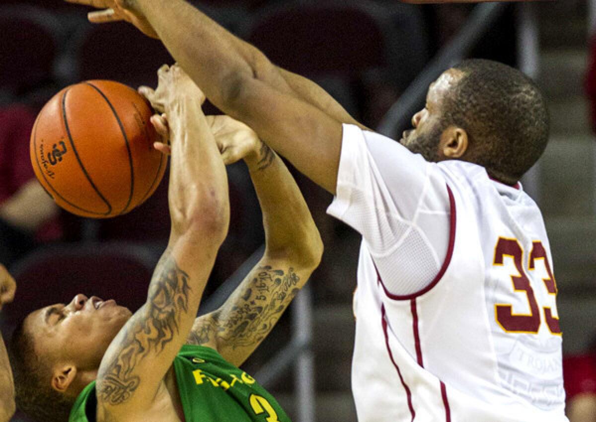 USC center D.J. Haley (33) blocks a shot by Oregon guard Joseph Young in the second half of their game on Saturday.