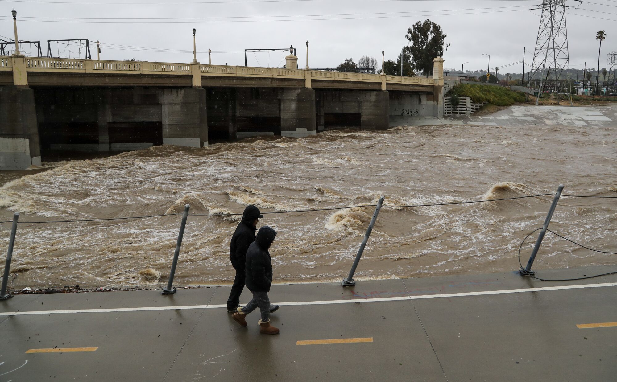 Pedestrians walk along the Los Angeles River in the Frogtown neighborhood on Saturday.