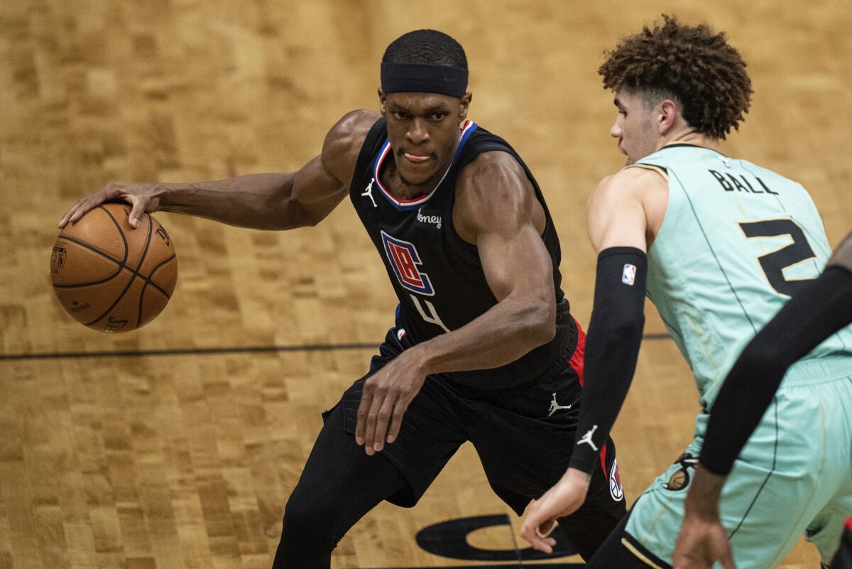 Clippers guard Rajon Rondo brings the ball up court while guarded by Charlotte's LaMelo Ball.