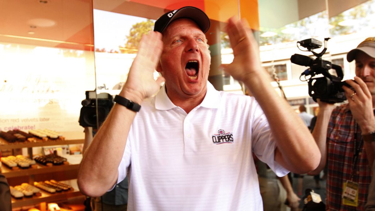 Clippers owner Steve Ballmer shouts to Clippers fans while giving away team gear at Sprinkles Cupcakes in downtown Los Angeles on Thursday.