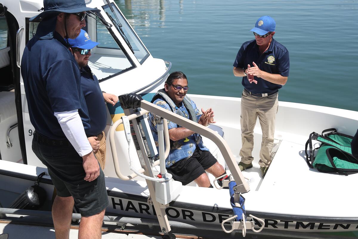 Bhumit Shah, a disabled boater, is lifted onto a power boat.