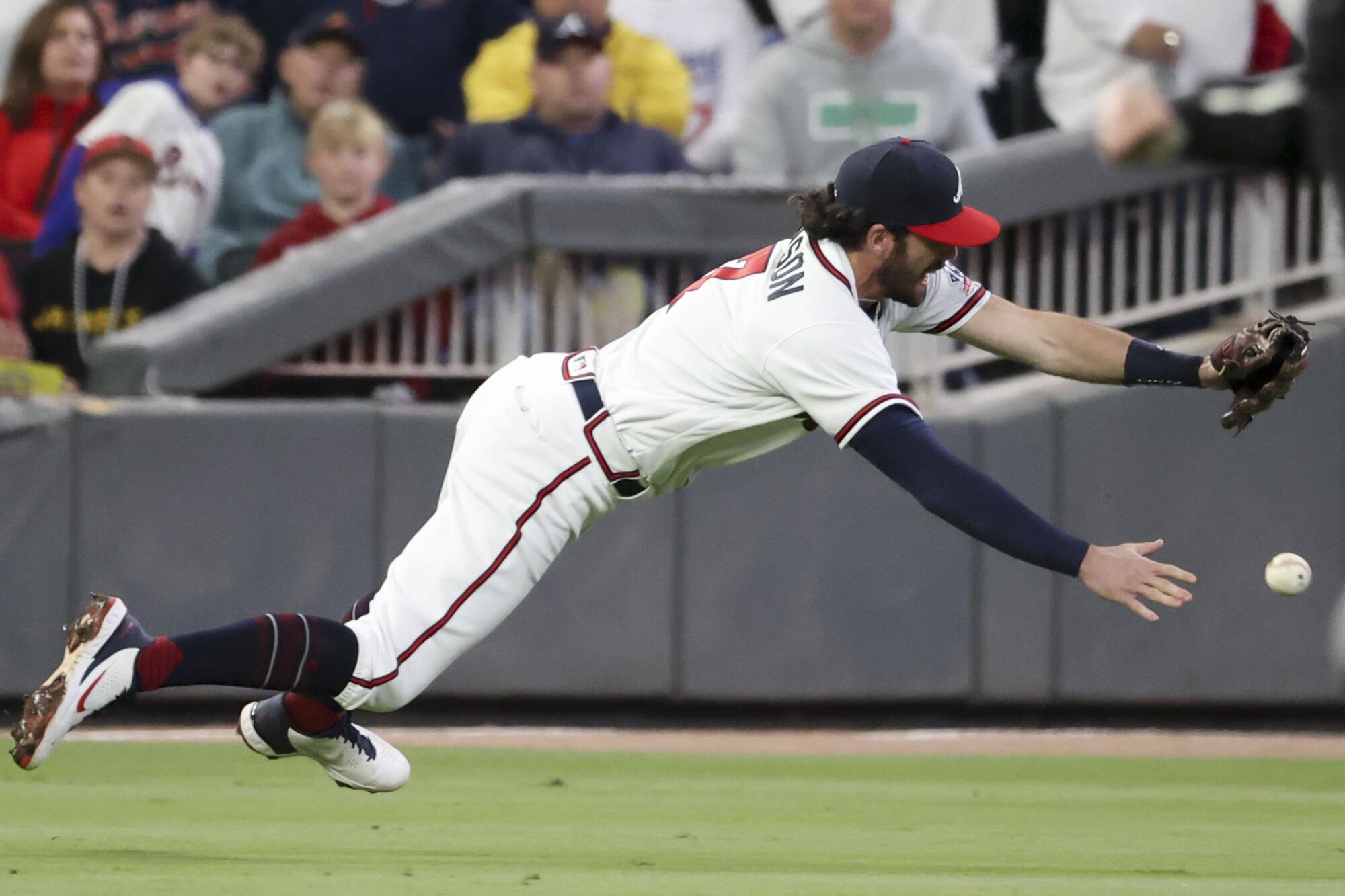 Braves shortstop Dansby Swanson is unable to make a play on a ball hit for a single by Dodgers' Mookie Betts