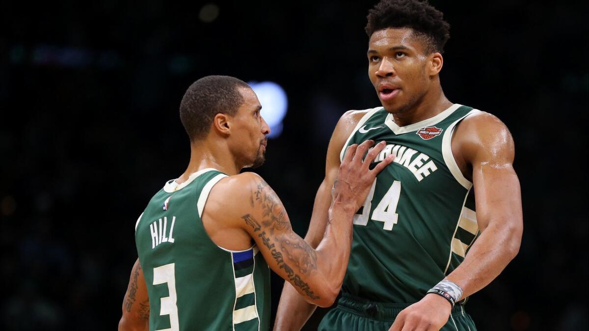 Bucks guard George Hill and forward Giannis Antetokounmpo celebrate a basket during a playoff game against the Celtics.