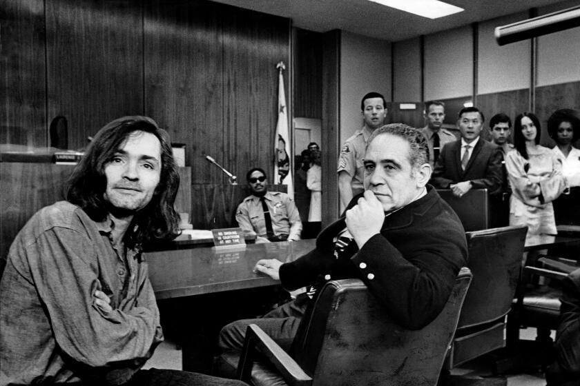 CLAIMS INNOCENCE ?€“ Charles Manson facing newsmen during a recess in Superior Court hearing into Gary Hinman slaying. Beside him is his attorney, Irving A. Kanarek. Photographer: George R. Fry / Los Angeles Times Date published in LA Times: June 19, 1970