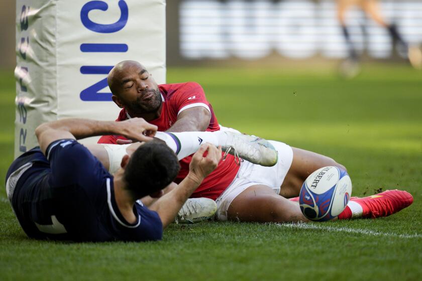 Tonga's Afusipa Taumoepeau, right, and Scotland's Blair Kinghorn fight for the ball during the Rugby World Cup Pool B match between Scotland and Tonga at the Stade de Nice, in Nice, France, Sunday, Sept. 24, 2023. (AP Photo/Daniel Cole)