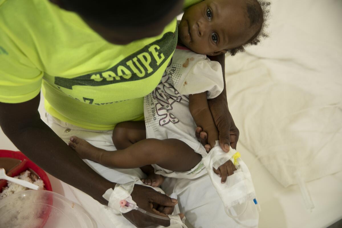 A baby stricken with cholera receives treatment at a clinic.