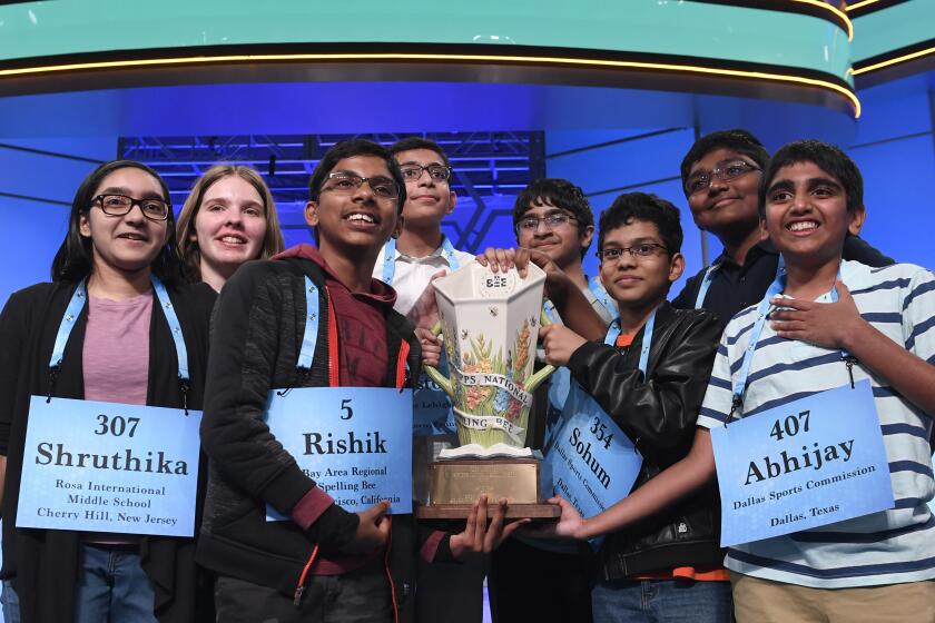 Co-champions of the 2019 Scripps National Spelling Bee, from left, Shruthika Padhy, 13, of Cherry Hill, N.J., Erin Howard, 14, of Huntsville, Ala., Rishik Gandhasri, 13, of San Jose, Calif., Christopher Serrao, 13, of Whitehouse Station, N.J., Saketh Sundar, 13, of Clarksville, Md., Sohum Sukhatankar, 13, of Dallas, Texas, Rohan Raja, 13, of Irving, Texas, and Abhijay Kodali, 12, of Flower Mound, Texas, hold the trophy in Oxon Hill, Md., Friday, May 31, 2019. (AP Photo/Susan Walsh)