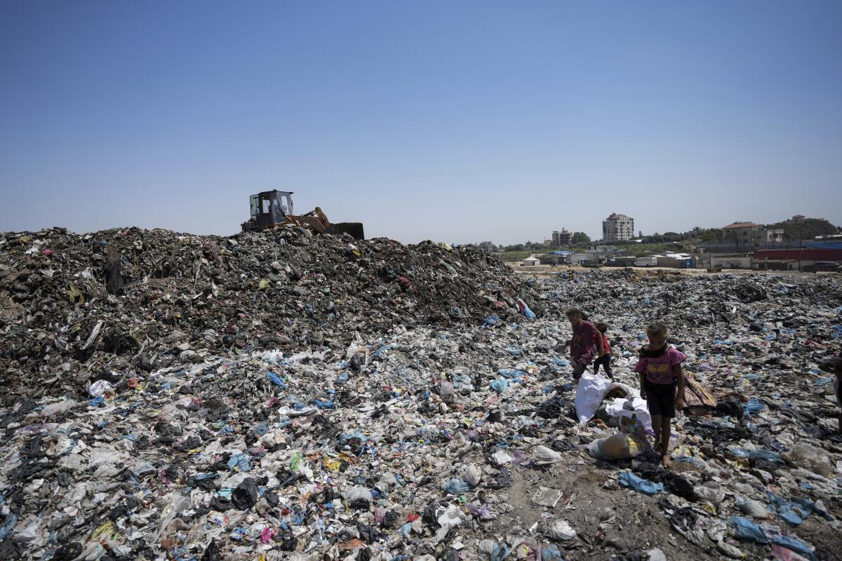 Palestinians sort through trash at a landfill in Gaza.